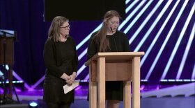 Elizabeth Marburger, left, wife of Dan Marburger, looks on as Clair Marburger, his daughter, speaks at his funeral in West Des Moines on Jan. 20.