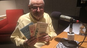 A man holds puzzle books