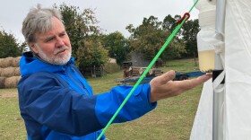  Tom Wassmer, a biology professor at Siena Heights University, points at a malaise trap, which is used to collect samples of flying insects for research.