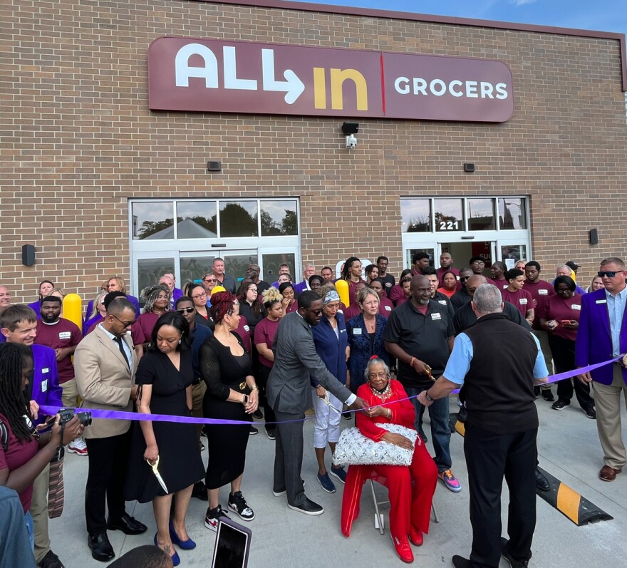 A purple ribbon is cut as a crowd looks on at the grand opening ceremony for All-in-Grocers and Grandma’s Hands restaurant on Oct. 3. in Waterloo.