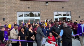 A purple ribbon is cut as a crowd looks on at the grand opening ceremony for All-in-Grocers and Grandma’s Hands restaurant on Oct. 3. in Waterloo.