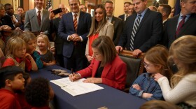 Gov. Kim Reynolds signs the Students First Act in the Capitol rotunda.