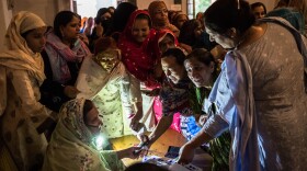 Pakistani women jostle to receive their ballot papers prior to casting their ballot at a polling station on May 11, 2013 in Lahore. A study in <em>The Lancet</em> provides evidence that free and fair elections are associated with a lower burden of chronic diseases.