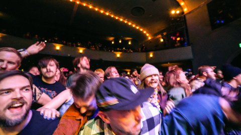 A crowd at a punk show lurches forward.