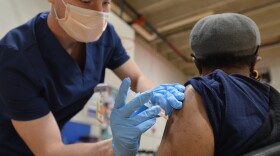 LPN Brice Headrick injects Anita Haney, 74, who showed up at Linwood YMCA for her first COVID-19 vaccination on Feb. 3.