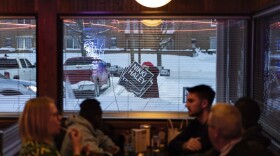 A campaign worker moves signs in front of Drake Diner in Des Moines, Iowa on Monday.