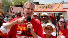 New York City mayor Bill de Blasio, speaks to protestors outside a McDonald's in Des Moines. The Democratic presidential candidate said he supports making $15-per-hour the national minimum wage.