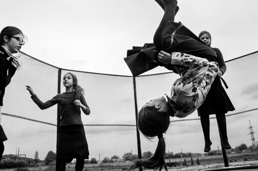 Girls play on a trampoline in 2016 during a break between classes in the village of Anatevka, Ukraine. They're among the thousands of Ukrainians who fled their homes in the Donbas region of eastern Ukraine, where intense fighting took place.