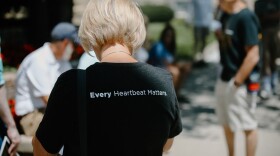 a woman wears a t-shirt that reads "every heartbeat matters"