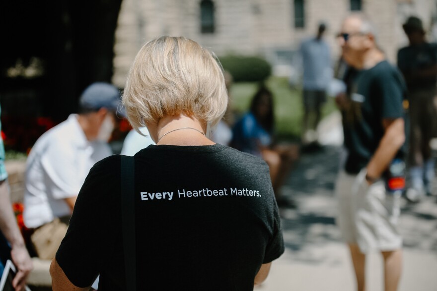 a woman wears a t-shirt that reads "every heartbeat matters"