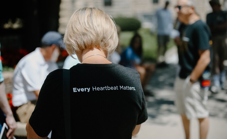 a woman wears a t-shirt that reads "every heartbeat matters"