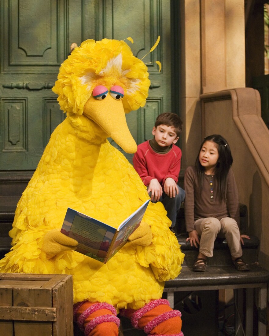 In this 2008 file photo, Big Bird reads to Connor Scott and Tiffany Jiao during a taping of <em>Sesame Street</em> in New York.