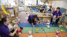 Caretakers play with children at a child care center in Iowa City