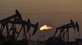 A flare burns off methane and other hydrocarbons as oil pumpjacks operate in the Permian Basin in Midland, Texas, Oct. 12, 2021.