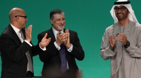 Sultan al-Jaber of the United Arab Emirates, right, celebrates the end of the COP28 climate meeting with United Nations Climate Chief Simon Stiell, left, and COP28 CEO Adnan Amin on Dec. 13, 2023, in Dubai. The final deal included a modest reference to transitioning away from fossil fuels, which scientists say is crucial to avoid catastrophic warming.