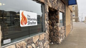 A building with a sign that reads 'The Warming Shelter' sits on a Sioux City street.