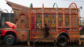 Painter Irfan Mohammad works on a truck at a sprawling workshop in Rawalpindi, Pakistan.