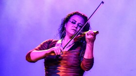 A female violinist plays with her eyes closed.