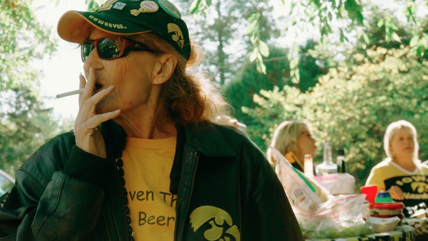 A woman stands with a cigarette in her mouth 