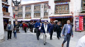 In this photo taken May 23, 2019, and released by the U.S. Embassy in Beijing, U.S. Ambassador to China Terry Branstad, center, walks along a street in Lhasa in western China's Tibet Autonomous Region. The U.S. ambassador to China urged Beijing to engage in substantive dialogue with exiled Tibetan Buddhist leader the Dalai Lama during a visit to the Himalayan region over the past week, the Embassy said Saturday.