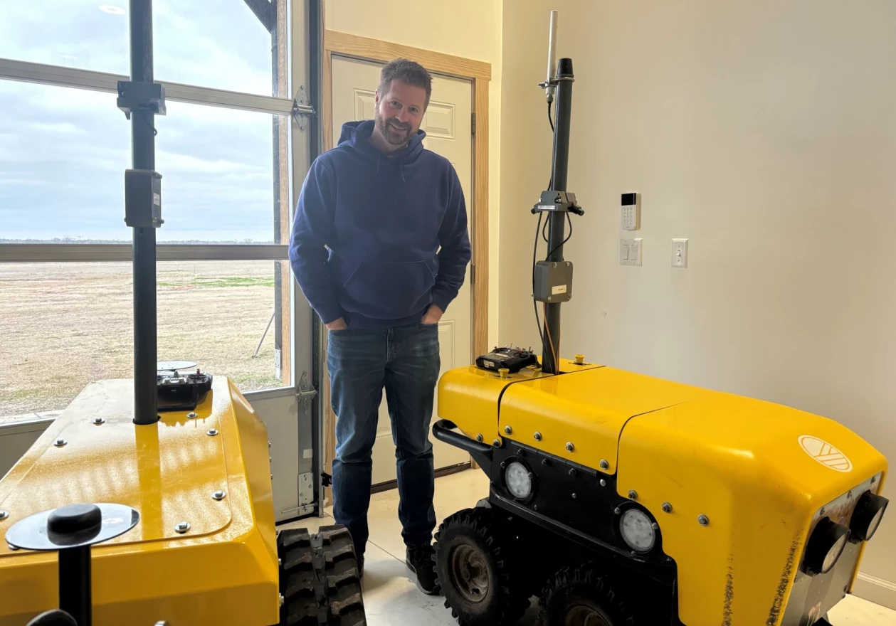 GreenField Robotics CEO and Founder Clint Brauer with two robots in Cheney, Kansas.