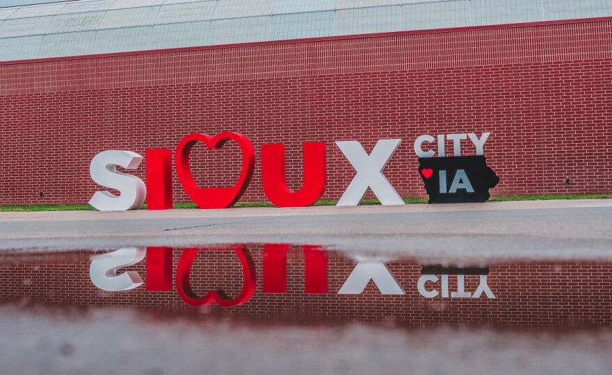 Photo of Sioux City sign in front of the Convention Center with a reflection of the sign in a pool of water.