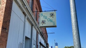 The outside of Byron's Bar has a sign with its name and dancing bears.