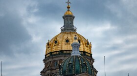 The northern side of Iowa's capitol gold dome on a cloudy afternoon.