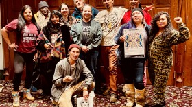 A group of people stand with a 'Truthsgiving' poster. 