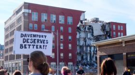 Protesters stand out the collapse site of an apartment building in Davenport on May 30. 