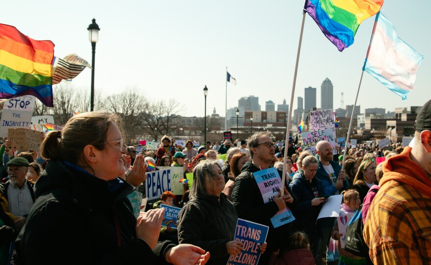 People hold signs in support of LGBTQ rights at a rally in Des Moines 