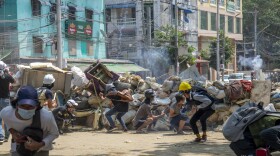 Policemen fire a charge as anti-coup protesters abandon their makeshift barricades and run in Yangon, Myanmar Tuesday, March 16, 2021. Demonstrators in several areas of Myanmar protesting last month’s seizure of power by the military held small, peaceful marches before dawn Tuesday, avoiding confrontations with security forces who have shot dead scores of their countrymen in the past few days. (AP Photo)