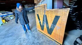 Alan Allsup, Iowa Wesleyan class of 1987, holds up the wood flooring from a now-dismantled gym.