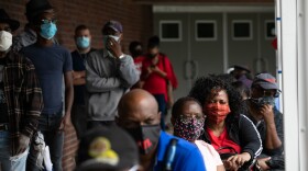 People wait in line on the first day of early voting for the general election on Oct. 12, 2020 in Atlanta.