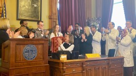 governor kim reynolds, doctors and lawmakers applaud a bill signing