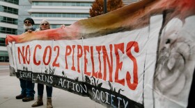 People hold sign reading "No CO2 Pipelines" made by the Great Plains Action Society.