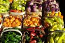 Several varieties of peppers in different colors sitting in baskets