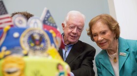 Former first lady Rosalynn Carter looks at a birthday cake with her husband, former President Jimmy Carter, during his 90th birthday celebration held at Georgia Southwestern University, Oct. 4, 2014, in Americus, Ga.