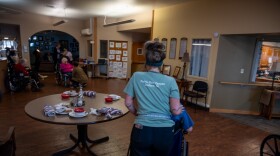 A worker at the Prairie View Nursing Home in Sanborn, Iowa, wheels a resident after lunch. The nursing home has faced chronic staffing shortages that were made worse by the COVID-19 pandemic.