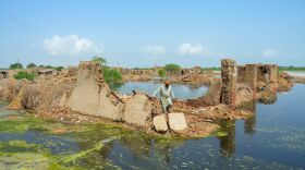 A man walks over his collapsed mud house after heavy monsoon rains in Jaffarabad district, Balochistan province, on Aug. 28.