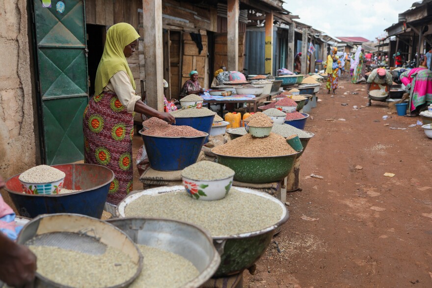 A vendor sorts grains at a market in Ghana. Fonio, a drought-resilient grain native to West Africa, could bolster the regional food supply if there are advances in its harvesting and processing.