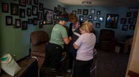  Employees at the Prairie View Nursing Home in Sanborn, Iowa, help a resident into a chair following lunch.