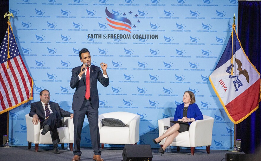 Republican Vivek Ramaswamy speaks to the crowd at the Iowa Faith and Freedom Coalition's spring kickoff event while Republican Party of Iowa chair and Iowa Attorney General Brenna Bird watch on April 22, 2023.