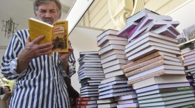 A visitor reads a book at a book fair during a Publishers Forum in Lviv, Ukraine, Wednesday, Sept. 19, 2018. A regional council in western Ukraine had passed a motion to ban all Russian-language books, films and songs in the region.