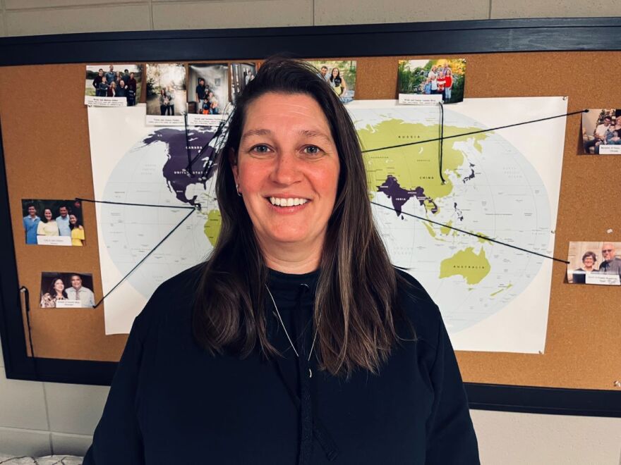 Martha Hulshof of Ireton stands in front of a map showing the missionary work of her church, Bethel Christian Reformed Church in Sioux Center. She is credited with helping 120 Ukrainians move to Iowa with more expected to arrive in a couple of months.