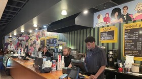 Fleur Cinema & Café staff stand behind the counter, ready to serve concessions to moviegoers.