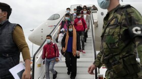 Afghan music students, teachers and their families disembark from their flight to Lisbon on Dec. 13. The group of more than 270 evacuees had been staying in Doha, awaiting resettlement in Portugal.