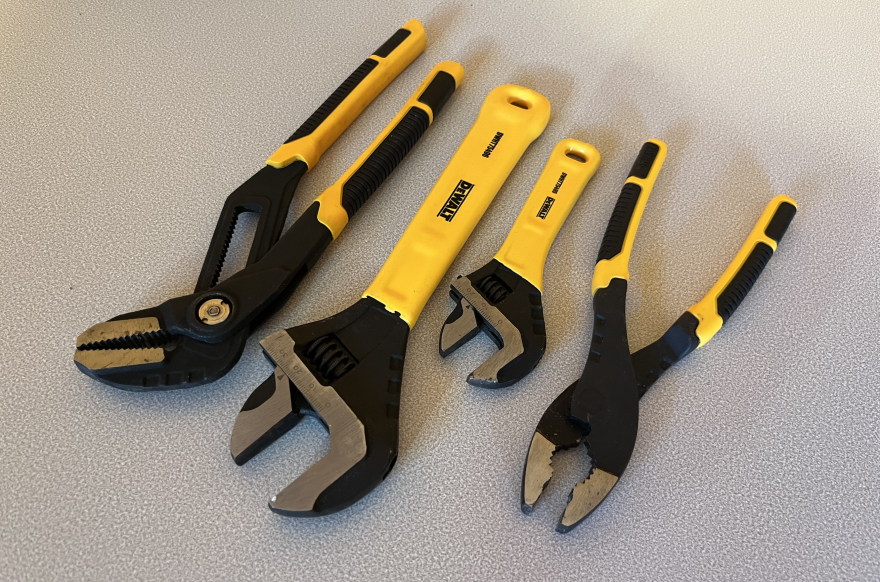 A tounge and groove plier, two adjustable wrenches, and a slip joint plier on a table