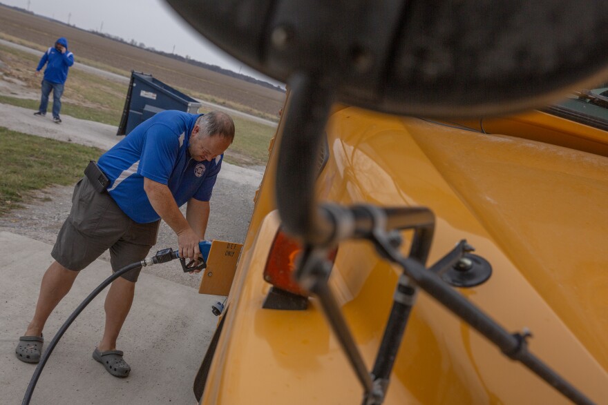 Eric Joiner, transportation supervisor for the Ralls County School District, fills a bus with diesel exhaust fluid on Monday, Nov. 20, 2023, in Center, Mo. While most buses in the school district’s fleet, such as this one, use diesel or gas engines, the school district has two electric buses. The electric buses are being rolled out in rural areas due to Inflation Reduction Act grants. 