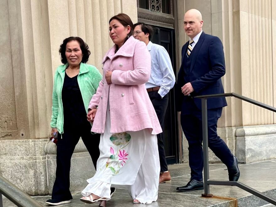 Four people are leaving a courthouse, including two women and two men.